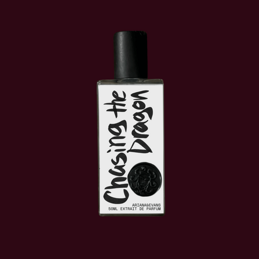 Perfume bottle labeled 'Chasing the Dragon' on a maroon background. Niche Fragrances