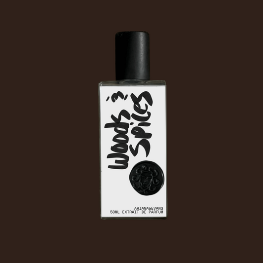 Perfume bottle with black cap and white label on a dark brown background. Indie Niche Fragrance